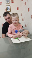 Девочка вместе с папой делает игрушку Девочка вместе с папой делает игрушку.
